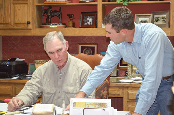 Sims standing and Frank Price discussing grazing plans.
