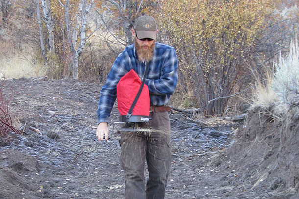 Hand-broadcasting seed to reclaim disturved soil 