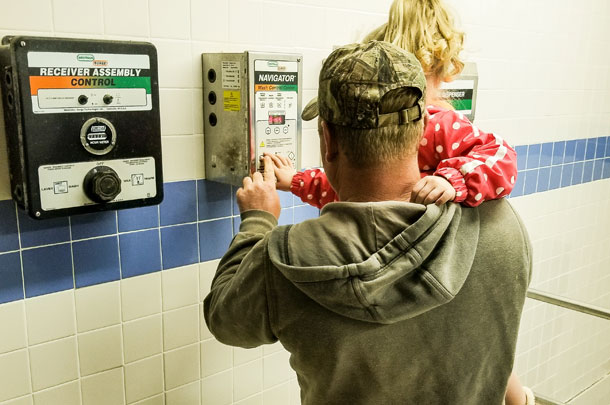 Baler pushes buttons in the milking parlor