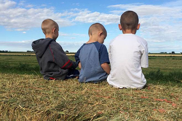 kids sitting on hay bale