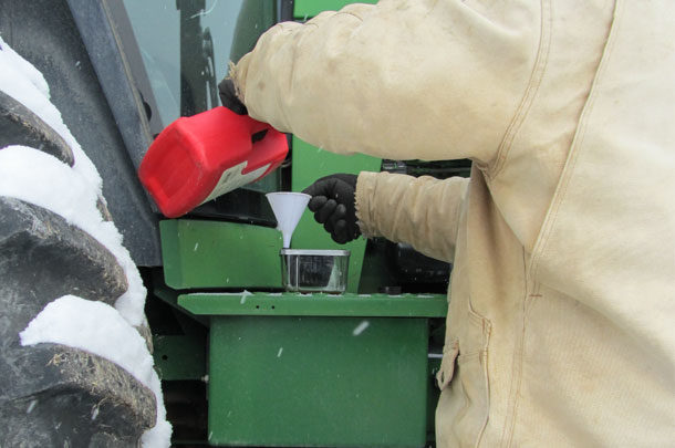 Michael Thomas fills the filter of his 4455 John Deere tractor