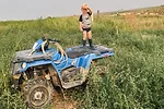 child standing on four-wheeler