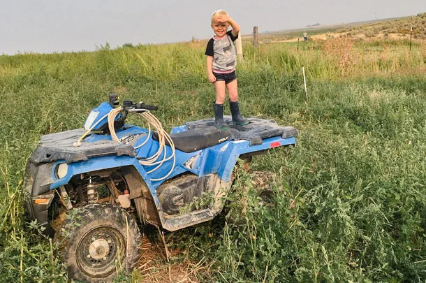 child standing on four-wheeler